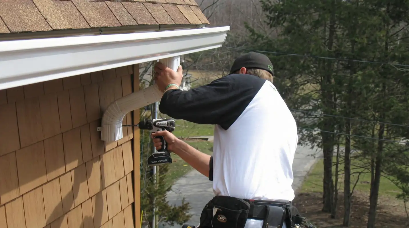 Professional contractor installing tan vinyl siding panels on a residential home exterior in Tempe, AZ